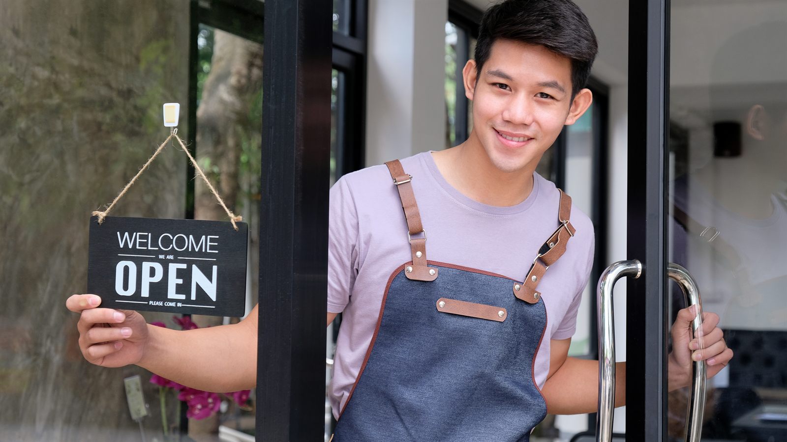 A Bocaue small-business owner welcoming customers with a WELCOME / OPEN sign at their store door